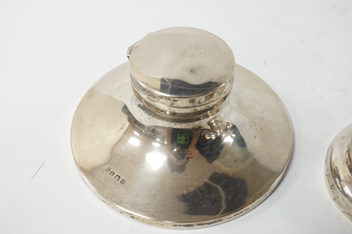 A George V Asprey & Co silver mounted brass cased timepiece, with Arabic dial and 8-day movement, the mount hallmarked for London, 1911, base diameter 72mm, together with a George V silver mounted capstan inkwell. Condit